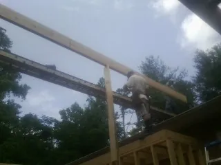 Carpenter setting a ridge beam over a new addition frame — Ice Dam Removal by Roofing Brothers in Mount Airy