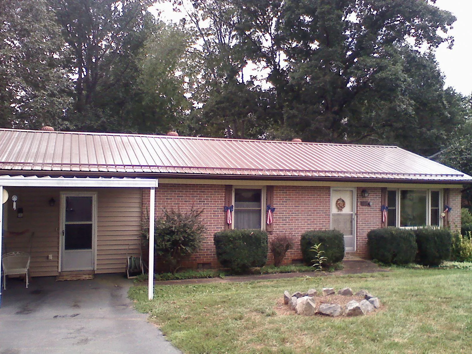 Bronze metal roof and carport on a brick ranch home — Roof Repair work by our crew in Mount Airy